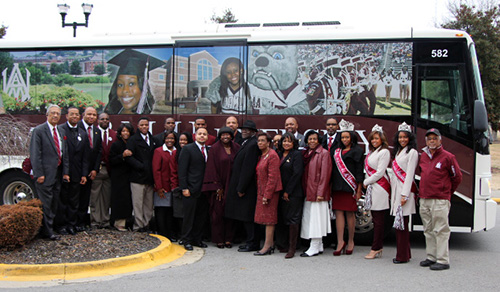 President and staff infront of AAMU bus
